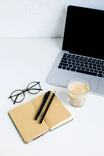 Laptop, bloco de notas e vidro de café — Fotografia de Stock