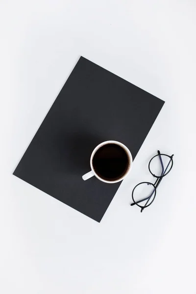 Cup of coffee on black paper — Stock Photo