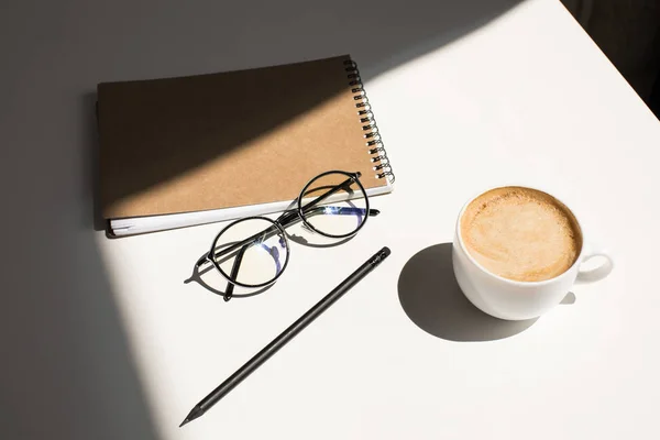 Café, anteojos y bloc de notas - foto de stock