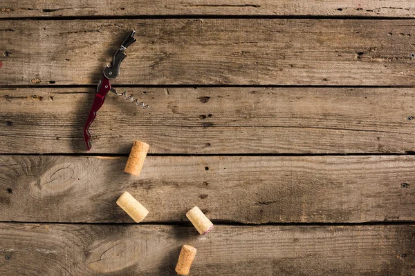 Tire-bouchon et bouchons sur plateau en bois — Photo de stock