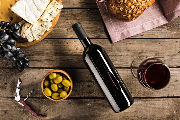 Wine, bread, olives and cheese — Stock Photo