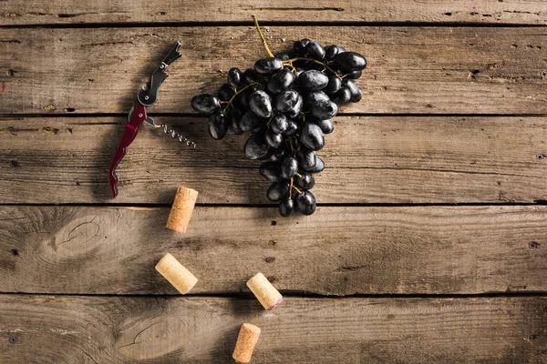 Corkscrew, corks and grapes — Stock Photo