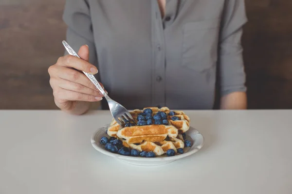 Woman eating waffles — Stock Photo