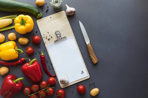 Verduras con papel en blanco y tabla de cortar - foto de stock