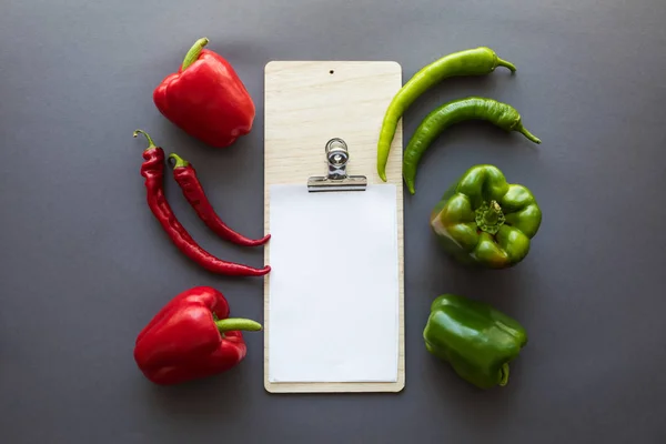 Peppers and blank paper sheet — Stock Photo