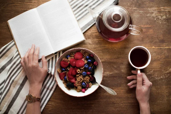 Mulher ler livro durante o café da manhã — Fotografia de Stock