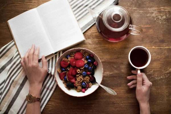 Donna che legge libro durante la colazione — Foto stock