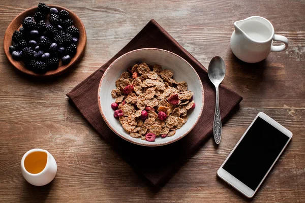 Corn flakes, berries and smartphone — Stock Photo