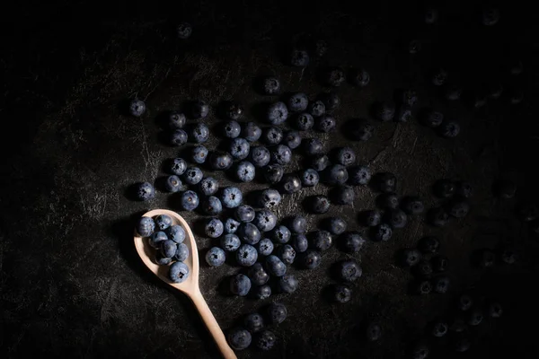 Blueberries and wooden spoon — Stock Photo