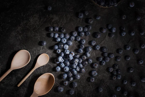 Blueberries and wooden spoons — Stock Photo