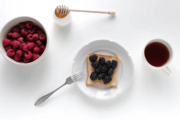 Tea and toast with berries for breakfast — Stock Photo