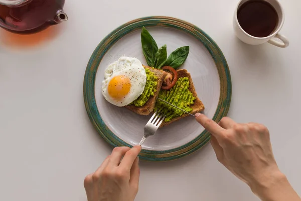 Spiegelei und Avocado auf Toasts — Stockfoto