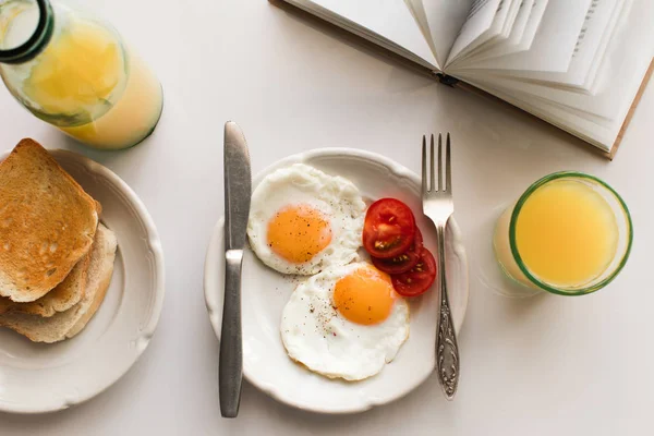 Desayuno con huevos fritos y zumo - foto de stock