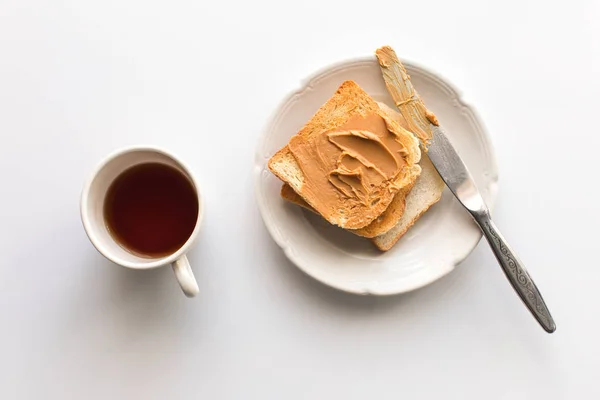 Toasts with peanut butter and tea — Stock Photo