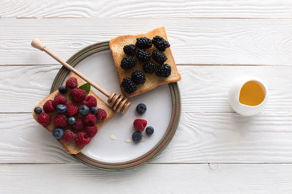 Fresh berries on toasts — Stock Photo