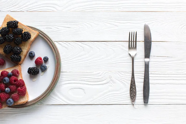 Breakfast with berries on toasts — Stock Photo