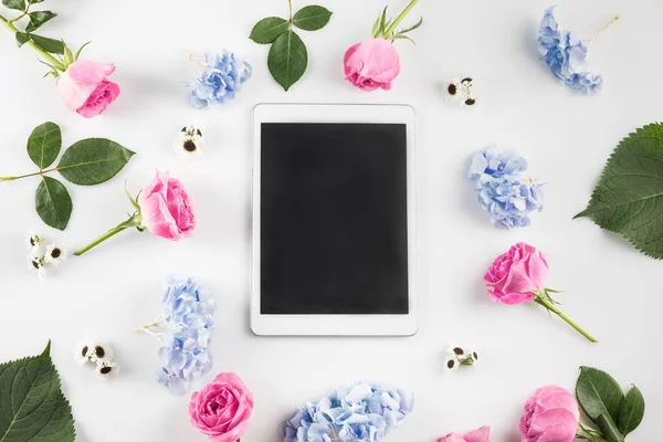 Цветы и цифровой планшет — стоковое фото