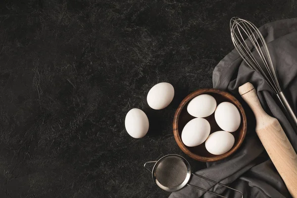 Huevos crudos y utensilios de cocina - foto de stock