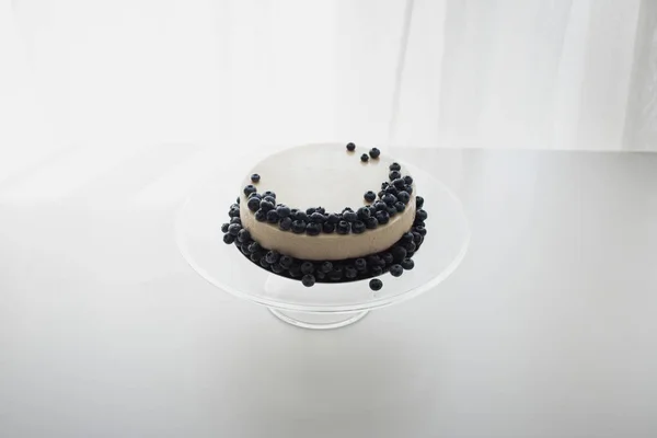 Cheesecake with blueberries on glass stand — Stock Photo