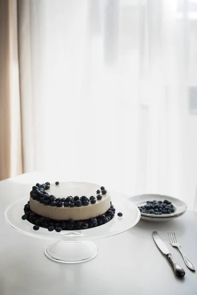 Cheesecake with blueberries on glass stand — Stock Photo