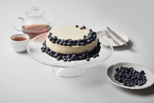 Cheesecake with blueberries on glass stand — Stock Photo