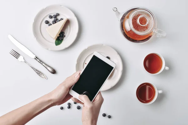 Woman taking photo of cheesecake — Stock Photo