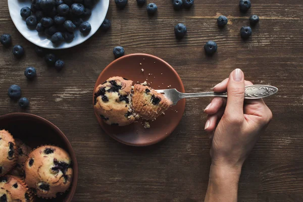 Persona che mangia muffin con mirtilli — Foto stock