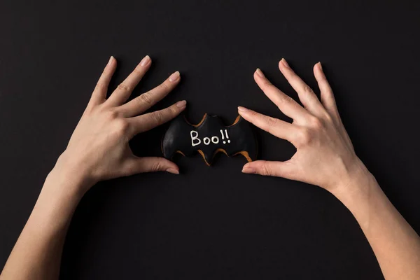 Manos con galleta de halloween - foto de stock