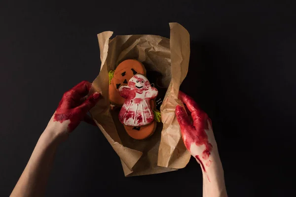 Manos envolviendo galletas de halloween — Stock Photo