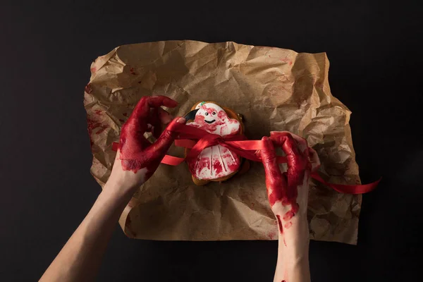 Mãos embrulhando biscoito halloween — Fotografia de Stock