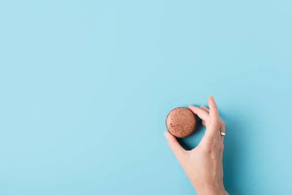 Mano femminile che tiene macaron — Foto stock