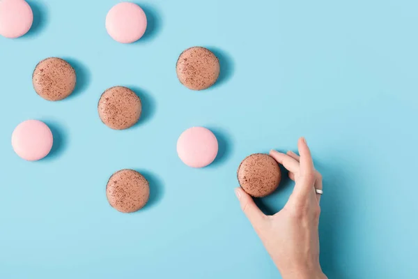 Weibliche Hand und Macarons — Stockfoto