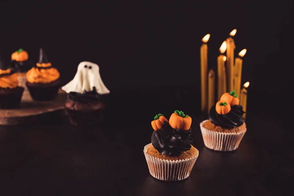 Cupcakes d'Halloween et bougies allumées — Photo de stock