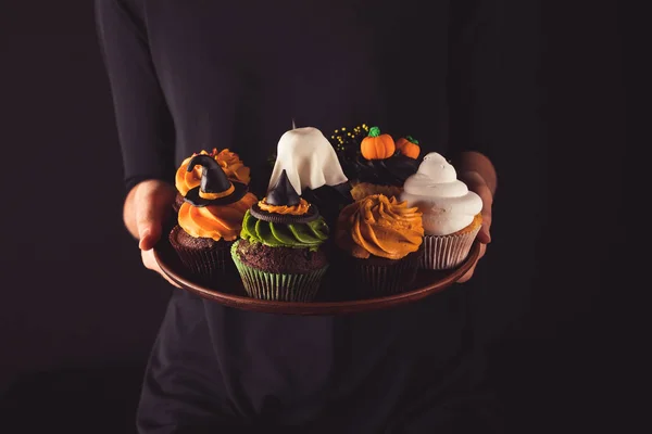 Person holding halloween cupcakes — Stock Photo