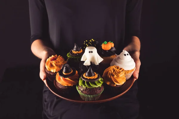 Person mit halloween Cupcakes — Stockfoto