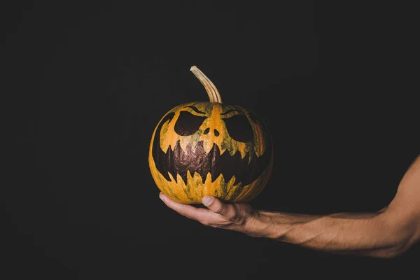 Man holding pumpkin with creepy face — Stock Photo