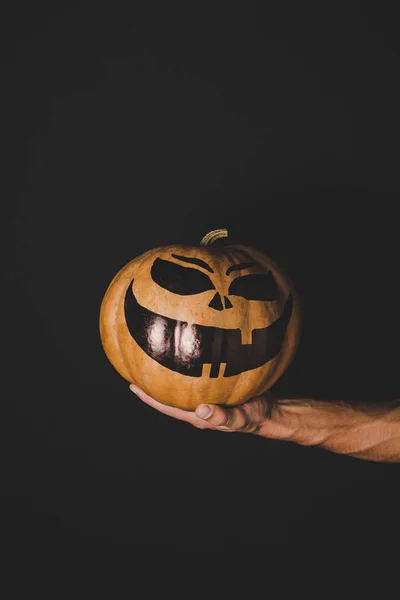 Man holding pumpkin with creepy face — Stock Photo