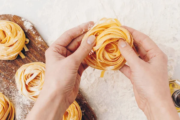 Woman holding raw pasta nest — Stock Photo