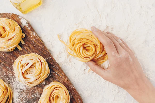 Donna con nido di pasta cruda — Foto stock