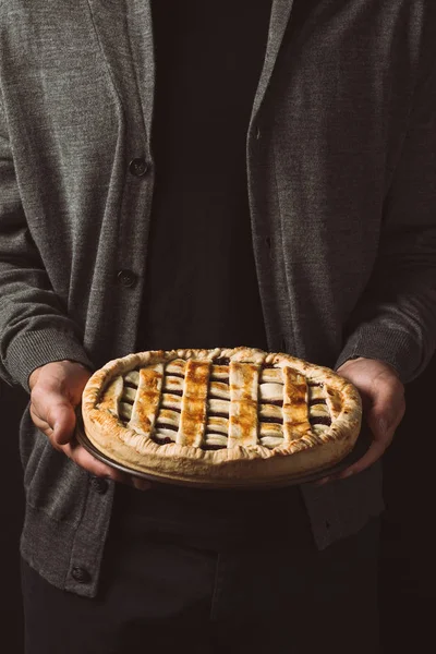 Uomo che tiene torta fatta in casa — Foto stock