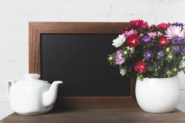 Flowers in vase and blank board — Stock Photo