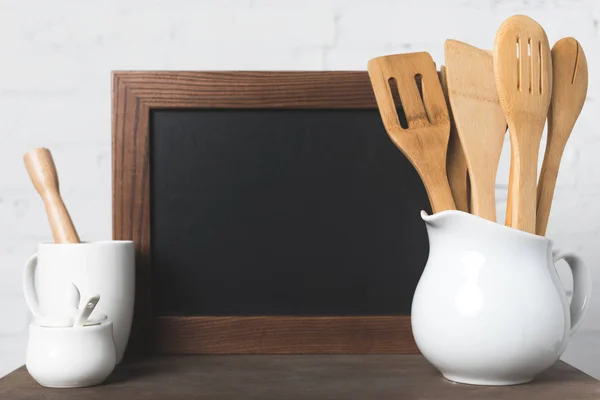 Tablero en blanco y utensilios de cocina - foto de stock