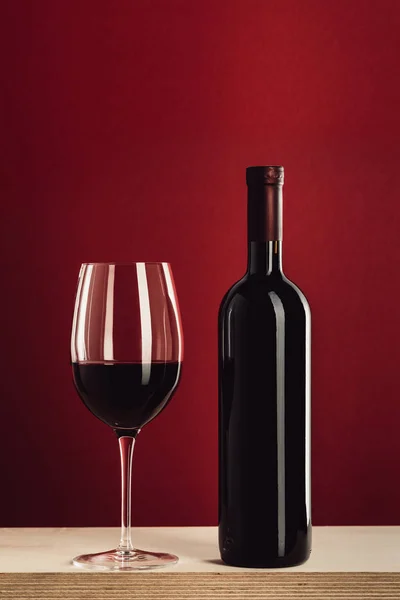 Copa y botella de vino tinto - foto de stock