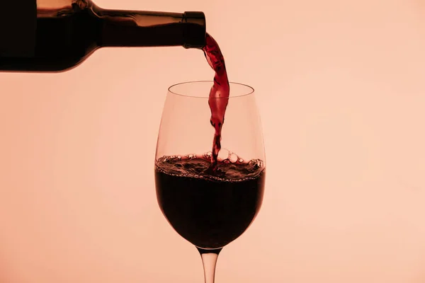 Красное вино, разливающееся в бокал — стоковое фото