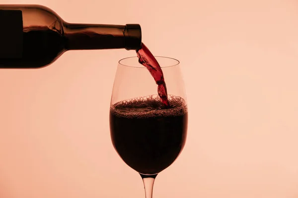 Vino tinto que sale de la botella - foto de stock