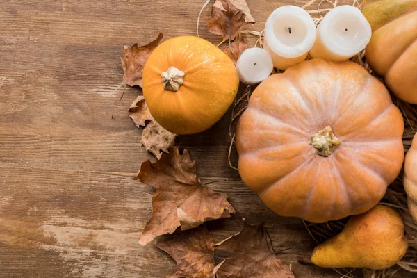 Calabazas y velas en la mesa - foto de stock