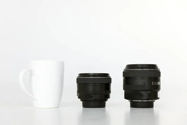 Lenses and coffee mug — Stock Photo