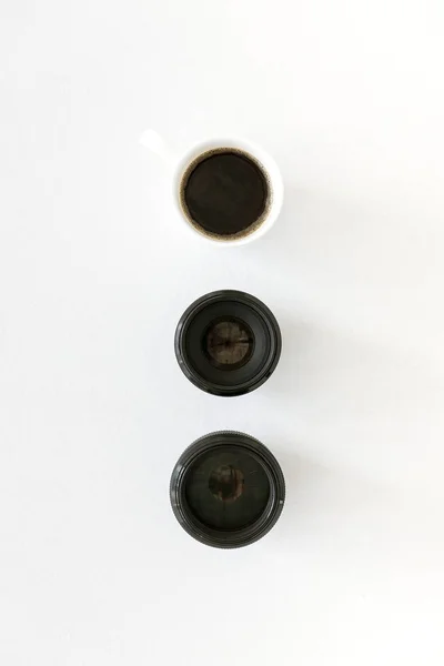 Lenses and coffee mug — Stock Photo