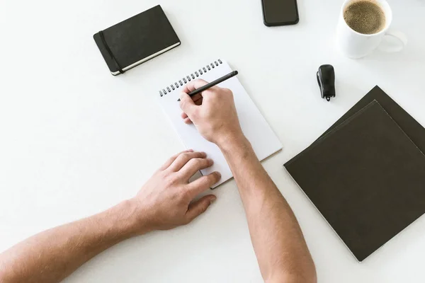 Manos masculinas escribiendo en bloc de notas — Stock Photo