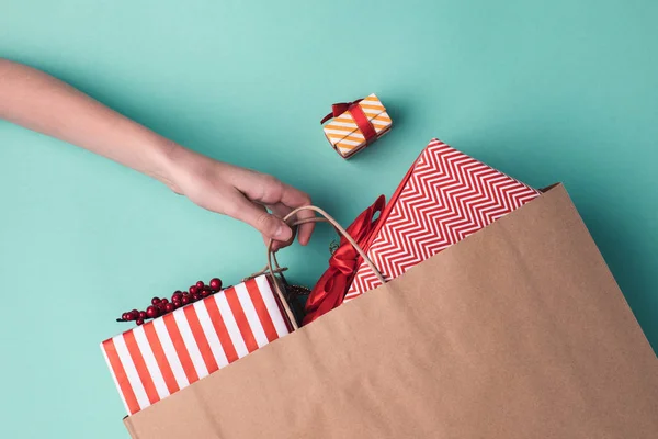 Hand holding paper bag with presents — Stock Photo